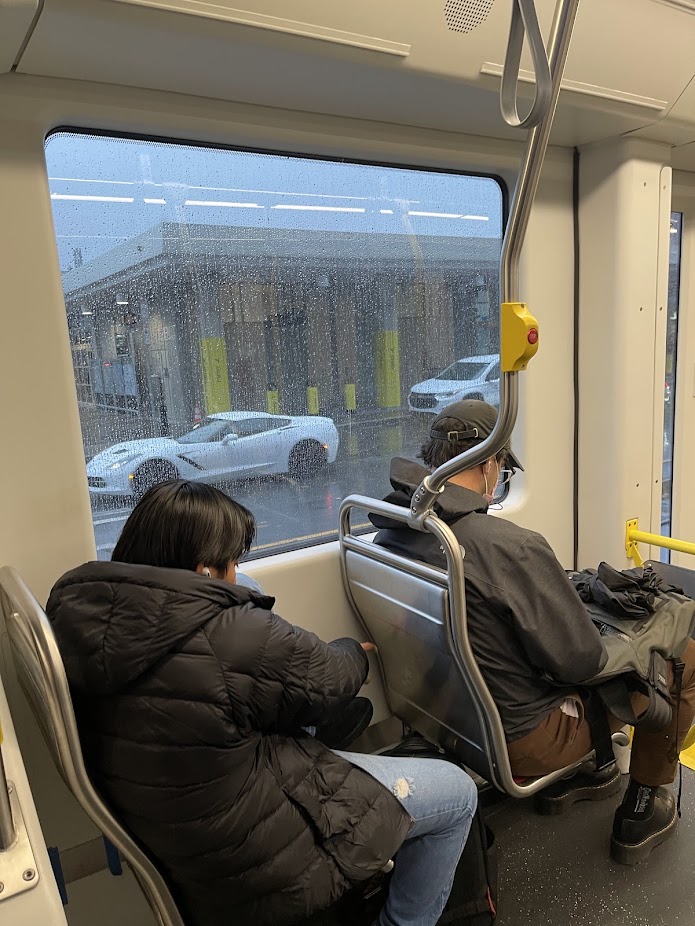 two people sitting on a train next to a rainy window